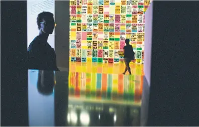  ??  ?? Visitors near The Singing Posters: Poetry Sound Collage Sculpture Book at the ‘Beat Generation’ exhibition at the Pompidou Center in Paris.