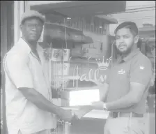  ??  ?? Sales Manager of Hallmark Guyana, Stephan Ramroop (right), a subsidiary of C&L Constructi­on Inc., hands over their support to Colin Boyce yesterday.