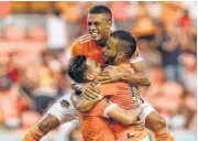  ?? Yi-Chin Lee / Houston Chronicle ?? Mauro Manotas, top, and Erick Torres, left, help Alex celebrate his first-half goal.