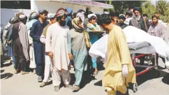  ?? NO OR MOHAMMAD/ AFP / GETTY IMAGES ?? Afghan villagers carry a dead body on a stretcher outside a hospital on Monday following an airstrike in Lashkar
Gah, the capital of Helmand province.