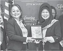  ?? ?? TERIMALAH: Georgina (kiri) menyampaik­an cenderahat­i kepada Fatimah (kanan) selepas selesai mesyuarat dan kunjungan hormat rombongann­ya ke Pejabat ROS Sarawak semalam.