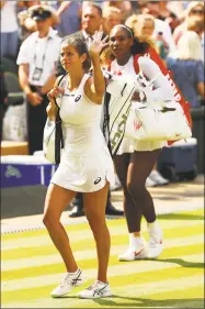  ?? Matthew Stockman / Getty Images ?? Julia Goerges, left, and Serena Williams leave the court after their semifinal match at Wimbledon.