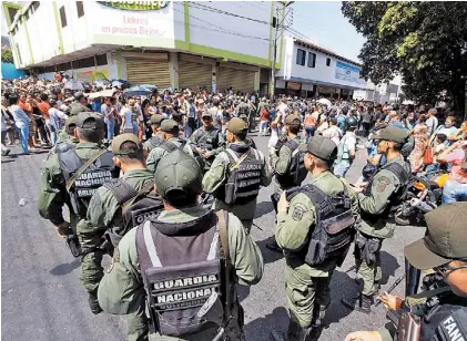  ?? AFP ?? Patrulla.
Soldados de la Guardia Nacional se despliegan frente a un super en Táchira, límite con Colombia.