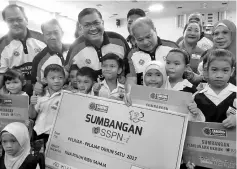  ??  ?? From second left: Raime, Shamsul, Rubin and Jainab with students who received the aid.