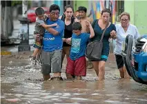  ?? PHOTOS: REUTERS ?? Residents cross a flooded street in Trujillo, northern Peru.