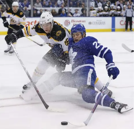  ?? RICK MADONIK/TORONTO STAR ?? Leaf William Nylander, serving as top-line centre, loses an edge while battling Matt Grzelcyk of the Bruins for a loose puck in Saturday’s game.