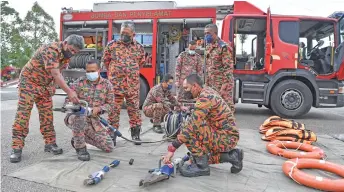  ?? — Bernama photo ?? Abdul Wahab (left) carries out an equipment check during his visit to the Malaysian Fire and Rescue Academy.