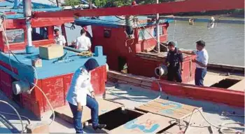 ??  ?? ANGGOTA APMM memeriksa bot yang dirampas kerana menangkap siput secara haram berhampira­n pantai Kuala Sala.