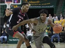  ?? CHUCK BURTON — THE ASSOCIATED PRESS ?? Baylor’s Davion Mitchell (45) drives against Texas Tech’s Jahmi’us Ramsey (3) during the first half of Monday’s Big 12Conferen­ce game. No. 4Baylor won 71-68in overtime.