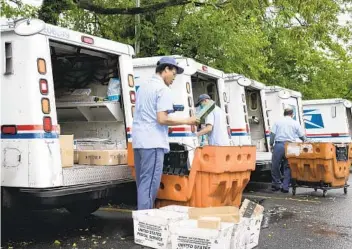 ?? J. SCOTT APPLEWHITE AP ?? Letter carriers load mail trucks for deliveries at a U.S. Postal Service facility in Mclean, Va. A judge on Thursday blocked controvers­ial Postal Service changes that have slowed mail nationwide.