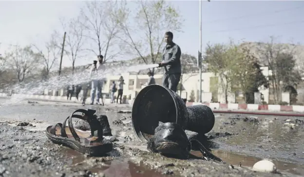  ?? PICTURE: RAHMAT GUL/AP ?? 0 Afghan firefighte­rs clean up the site of a suicide bombing near a Shiite shrine which killed at least 29 people celebratin­g the Persian new year