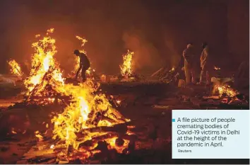  ?? Reuters ?? A file picture of people
■ cremating bodies of Covid-19 victims in Delhi at the height of the pandemic in April.