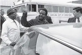  ?? ASSOCIATED PRESS FILE PHOTO ?? The Rev. Ralph David Abernathy gives the victory sign in 1969 as he is escorted back to jail from Charleston County Court in Charleston, S.C., where he and others were taken for hearings on violating an injunction limiting pickets at two hospitals. The...