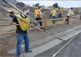  ?? Dan Watson/ The Signal ?? (Above) Kyle Coulon, left, helps break up old irrigation pipes during the Church of Jesus Christ of Latter-day Saints’ Day of Service beatificat­ion project at the Newhall Park and Ride on Saturday. (Left) Jay Neser, 10, right, joins hundreds of volunteers as he helps spread some of the hundreds of yards of mulch.