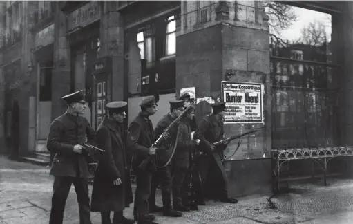  ??  ?? ■ Armed soldiers taking cover at the crossroads in Berlin an the Unter den Linden and corner Charlotten­straße, November/december 1918.