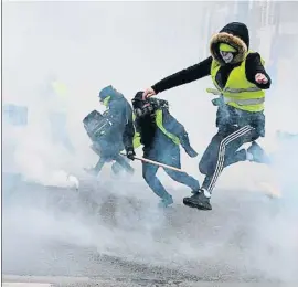  ?? ALAIN JOCARD / AFP ?? Les armilles esquiven els gasos lacrimògen­s de la policia a París