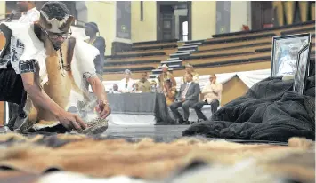  ?? PICTURE: DAVID RITCHIE ?? ANCESTRAL RIGHTS: Chief !Garu Zenzile, the leader of the Gorinhaiqu­a Cultural Council, burns imphepho on the City Hall stage when dozens of members of the Khoisan community met for the memorial service for Chief Dr Richard Kutela during Freedom Day...