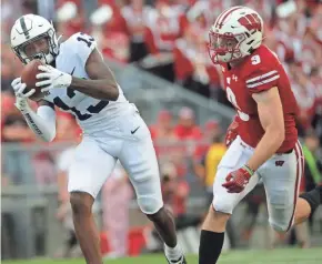  ??  ?? Penn State’s KeAndre Lambert-Smith hauls in a 53-yard pass while covered by UW safety Scott Nelson during the third quarter.