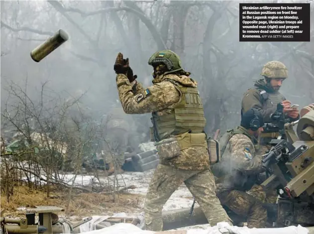  ?? AFP VIA GETTY IMAGES ?? Ukrainian artillerym­en fire howitzer at Russian positions on front line in the Lugansk region on Monday. Opposite page, Ukrainian troops aid wounded man (right) and prepare to remove dead soldier (at left) near Kremenna.