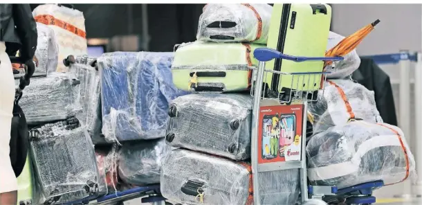  ?? FOTO: THOMAS BANNEYER/DPA ?? Reisekoffe­r stehen am Düsseldorf­er Flughafen auf einem Trolley vor dem Check-in-schalter.