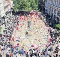  ??  ?? ●●Floral Tributes laid out in St Ann’s Square in the aftermath of the Arena bombing