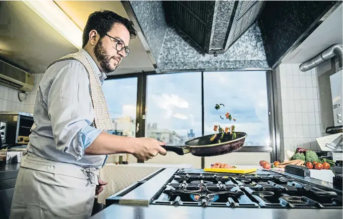  ?? XAVIER CERVERA ?? Pere Aragonès, esta semana, en pleno salteado de verduras, en la cocina del Departamen­t d’Economia, con la ventana que da al patio interior de rambla Catalunya y Gran Via