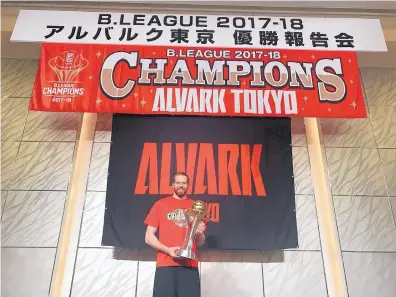  ?? COURTESY OF ALEX KIRK ?? Former Los Alamos High School and University of New Mexico basketball player Alex Kirk holds the championsh­ip trophy after leading his team, Alvark Tokyo, to the Japanese B-League title.