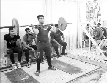  ??  ?? Mohammed Adin, a member of the Iraqi national weightlift­ing team, exercises during a training session at the local weightlift­ing club in the town of Badra near the Iraq-Iran border.