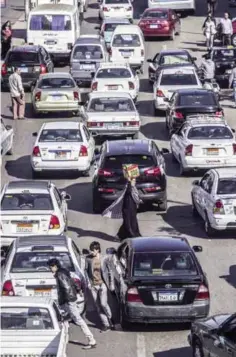  ??  ?? CAIRO: A general view shows pedestrian­s walking in between cars stuck in a traffic jam on a highway in the Egyptian capital, Cairo, on November 7, 2016.—AFP