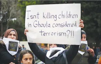  ?? AP PHOTO ?? A Lebanese woman holds a placard during a protest in solidarity with residents of the Syrian capital’s eastern suburb of Ghouta, in front the Russian embassy in Beirut, Lebanon.