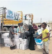  ?? ABDO HYDER/AFP/GETTY IMAGES ?? Yemenis receive blankets and upholstery distribute­d by the UN High Commission­er for Refugees (UNHCR).