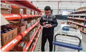  ??  ?? An employee of a logistics company serving cross-border e-commerce platforms prepares stock for the annual “Double 11” shopping spree in a warehouse in Chongqing on October 10, 2018