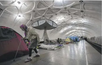  ?? MSTYSLAV CHERNOV/AP ?? An elderly woman walks inside a metro station being used as a bomb shelter in Kharkiv, Ukraine, Thursday.