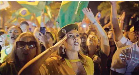  ?? FOTO: CORREA/DPA ?? Salutieren für den Präsidente­n: Die Anhänger Jair Bolsonaros feiern den Sieg ihres Kandidaten vor dessen Wohnung in Rio de Janeiro.