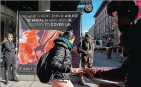  ?? PAULO NUNES DOS SANTOS/THE NEW YORK TIMES ?? Volunteers for Irish Center for Bio-Ethical Reform distribute pamphlets at a protest outside the offices in Dublin on March 7.