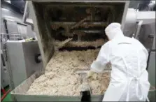  ??  ?? A worker looks inside the machine that mixes the ingredient­s for Bibigo dumplings at an automated factory of CJ CheilJedan­g Corp. in Incheon, South Korea.