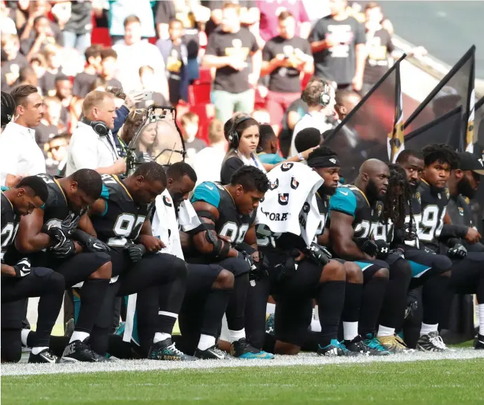  ?? Reuters ?? Jacksonvil­le Jaguars players, above, and their opponents, the Baltimore Ravens, knelt during the US national anthem ahead of their NFL game at Wembley Stadium in London