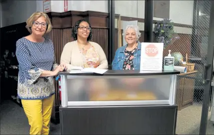  ?? DANIELLE RAY / SENTINEL & ENTERPRISE ?? From left, Fitchburg Senior Center Executive Director Joan Goodwin, clerk Jennifer Brennen, and receptioni­st Kathy Deery stand at the new reception desk where seniors will be screened before entering the center.