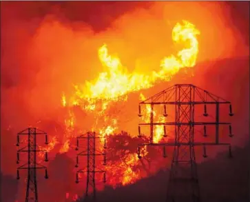  ?? Mike Eliason Associated Press ?? FLAMES APPROACH power lines in Sycamore Canyon as a f ire rages in Santa Barbara County in July 2019. Today’s forecasts of wildfire spread are based on a web of remote weather stations, cameras and satellites.