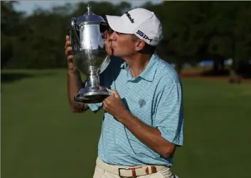  ?? Associated Press ?? Jim Herman kisses the championsh­ip trophy after winning the Wyndham Championsh­ip on Sunday at Sedgefield Country Club in Greensboro, N.C.