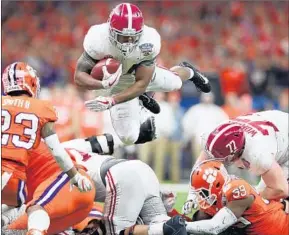  ?? Tom Pennington Getty Images By David Wharton ?? DAMIEN HARRIS of Alabama dives for yardage during Monday night’s game. The running back helped the Crimson Tide deliver their physical brand of football.