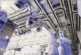  ?? Photo provided by Global Foundries ?? Workers watch silicon wafers buzz around from machine to machine at Globalfoun­dries’ Fab 8 plant in Malta.