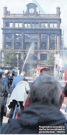  ?? PRESS EYE ?? People look on yesterday as the Fire Service still work to put out the blaze