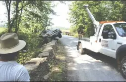  ?? Photo by Alex Sharp Viii/rappahanno­ck News ?? A tow truck hauls Cecelia Velasco’s wrecked truck out of the Jordan River on Bean Hollow Road in Flint Hill last Thursday (June 21).