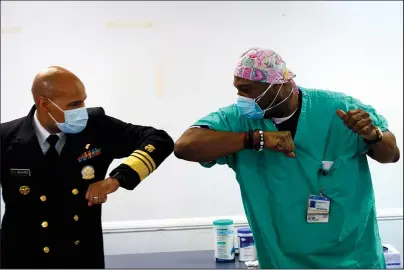  ?? The Associated Press ?? ELBOW BUMP: Surgeon General of the U.S. Jerome Adams, left, elbow bumps Emergency Room technician Demetrius Mcalister after Mcalister got the Pfizer COVID-19 vaccinatio­n Tuesday at Saint Anthony Hospital in Chicago.