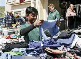  ?? ?? (Left) Boy Scouts Troop 303 member Havish Arun helps organize clothes to be sold. (Right) Cynthia Wickman, mother of Eagle Scout candidate Joseph Wickman-vilaubi, packs items to be sold to help her son raise money for his service project.