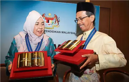  ??  ?? Dedicated teachers: Nawi (right) and Asariah with their awards during the National Teachers Day Celebratio­n 2019.