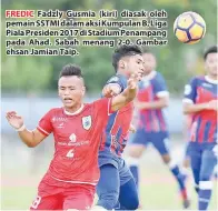  ??  ?? FREDIC Fadzly Gusmia (kiri) diasak oleh pemain SSTMI dalam aksi Kumpulan B, Liga Piala Presiden 2017 di Stadium Penampang pada Ahad. Sabah menang 2-0. Gambar ehsan Jamian Taip.