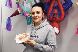  ?? CATHY COOK/EL DEFENSOR CHIEFTAIN ?? Rebecca Apodaca shows off one of the candy store’s paletas. The paletas come from Albuquerqu­e.