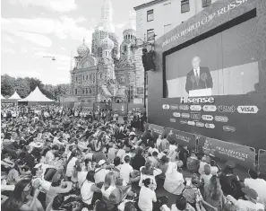  ?? DMITRI LOVETSKY / THE ASSOCIATED PRESS ?? People watch as Russian President Vladimir Putin delivers a speech on Thursday prior to the World Cup match between Russia and Saudi Arabia.